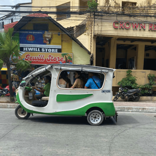 solar tuk-tuk driving past a hotel in the Philippines