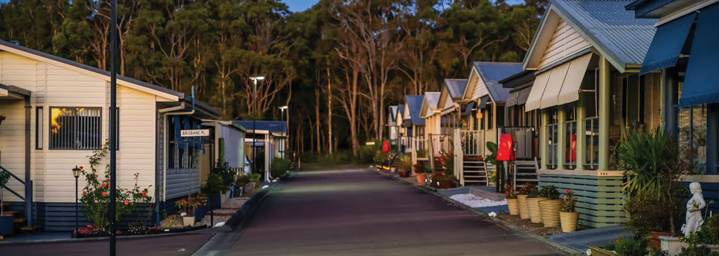 row of solar street lights shining brightly on road through aged care facility