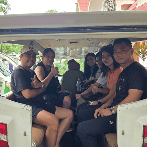 8 passengers smiling in the back of an electric tuk-tuk in Australia