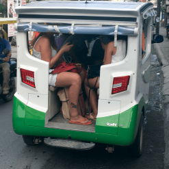 Tourists sitting inside a solar tuk-tuk in The Philippines