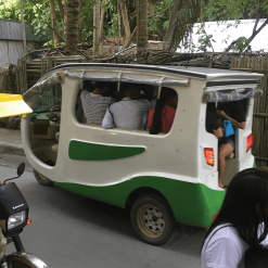 Solar tuk-tuk transporting people on a busy road in the Philippines